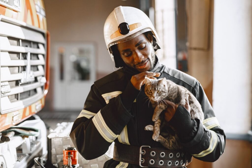 Firefighter in uniform caring for a rescued cat indoors. Professional and compassionate service.